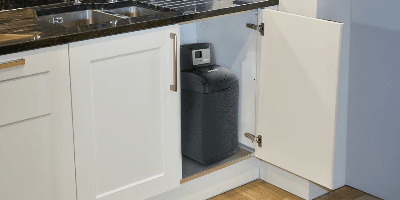 Mały zmiękczacz wody BWT Bewasoft zainstalowany pod zlewem kuchennym.